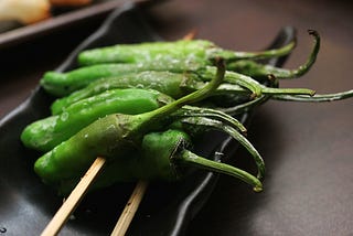 a bunch of pimientos in skewers laid on a plate