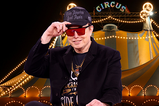 Elon Musk wearing black MAGA hat with circus tent behind him