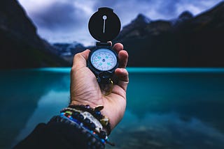An image of a white person holding a compass for navigation