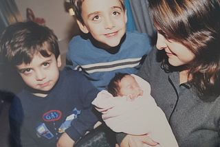 Image by author; 12/11/2001; Seattle, WA. Pictured from left: Brandon (age 3), Brashaw (age 5), Baby Brooke, and author holding baby.