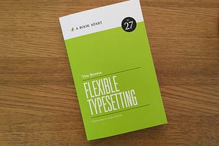 Photo of a physical copy of Flexible Typesetting on a wooden surface.
