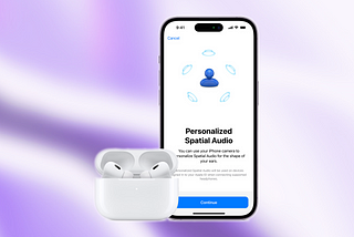 AirPods Pro 2nd Generation in their case, open. Behind them is an iPhone with the “Personalized Spatial Audio” screen from AirPods Settings. The image features white background and a very clean look, typical to usual Apple Press Photos.