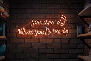 Neon sign that reads you are what you listen to.