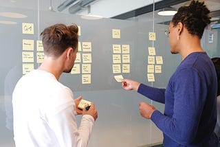 Two adults looking at an agile scrum board