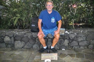 Joe sitting on a stone wall in Waikiki — Panhandling for Cannabis when I was Homeless