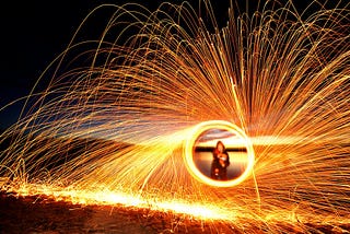 a time lapse photo of a person surrounded by swirling sparks
