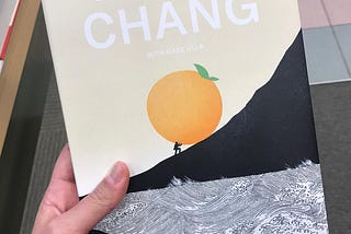 Copy of David Chang’s Eat a Peach Memoir. Small man rolls orange fruit up a hill.