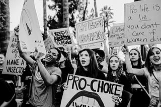 Black and white photograph of women protesting and holding up pro-choice placards.