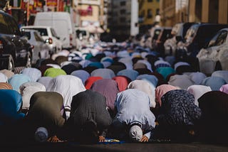 Muslims praying on Friday in Dubai. The congregation has spilled onto the road outside of the mosque.