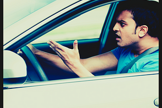 man behind the wheel of the car