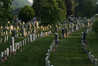 Headstones with small American flags at the cemetery of the United States Military Academy, West Point, on Memorial Day, 2016.