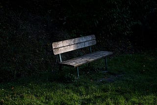 Photo of a dark brown bench with a dark background