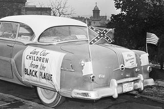 “Salve nossas crianças da praga negra”
 
Bandeira dos Estados Confederados e dos EUA tremulam em carro estacionado no Capitol Hill, em Nashville, onde o então governador Frank Clemente se encontrava com uma delegação de partidários do segregacionismo em 24 de janeiro de 1956.