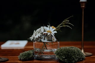 A small wedding centerpiece of foraged flowers and mosses.
