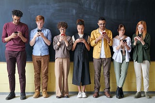 An image depicting a group of teenagers of diverse ethnic backgrounds engrossed in their smartphones