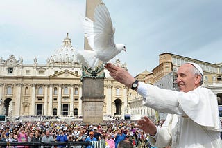 Pope Francis, in foreground, releases a dove before a crowd of onlookers in St. Peter’s Square, Rome.