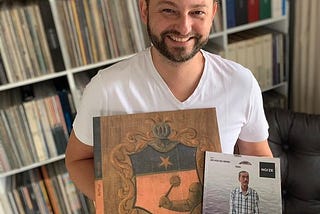 Airton carregando um exemplar de “No Voo do Urubu” (2016) de Arthur Verocai lançado pela NOIZE Record Club