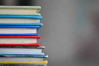 A stack of well-read books in various lengths and colors.