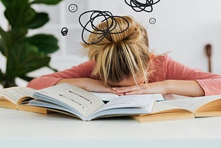 Student has her head down on her open text book