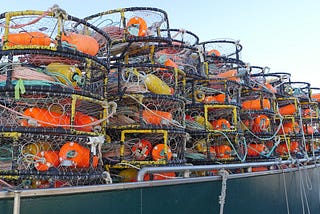 Stacks of crab pots fill the deck of a fishing boat.