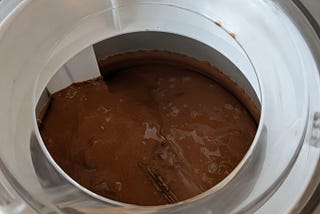 View from above of ice cream mix, just starting to churn, in a Cuisinart ICE-20 countertop ice cream freezer.