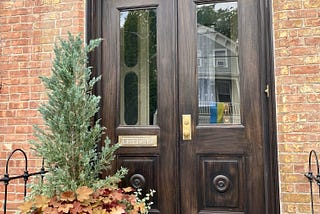 Doorway of brick home with planter on left