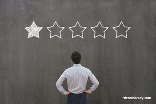 man looking at a large chalkboard with 5 big stars and only one is shaded in representing a one-star review