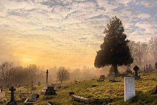 Sunrise at picturesque cemetery with heasdstones