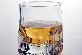 A half-filled square-shaped glass of whisky