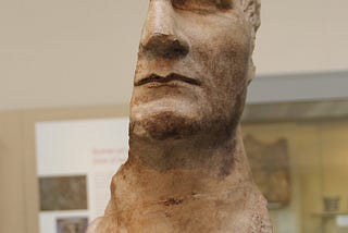 A broken bust of Caesar’s head, split asunder vertically.