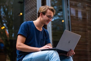 An engineer, designer, or entrepreneur can use Product Hubb from anywhere at any time. Here, someone uses a MacBook at a park. to check their project on the go.