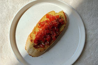 A Lovely Bruschetta topped with rich tomatoes in garlic and herbs tossed with olive oil and some baslamic. Tasty bruschetta recipe.