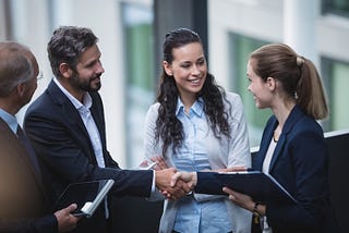 Photo of men and women meeting and a smile and handshake dispelling any sense of mistrust or fear.