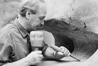 Black and white picture of a sculpturer Henry Moore at work.