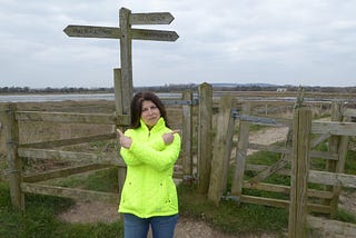 Women standing at a public footpath crossroads, pointing in both directions