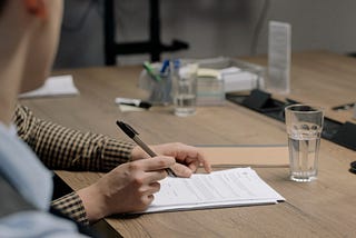 A person looking over a contract, ready to sign