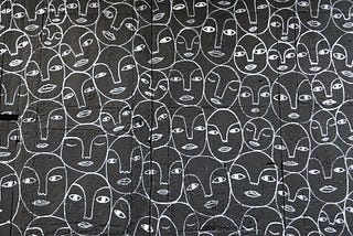 Repeating pattern of drawn faces.