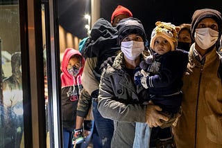 Group of immigrant families staring at the camera, anxiously wait to board a bus for transport to a U.S. Border Patrol processing center on December 09, 2021