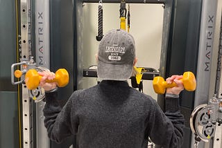 Older woman doing bicep curls in the Fitness Center