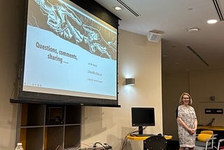 Jennifer standing in front of a screen following her presentation