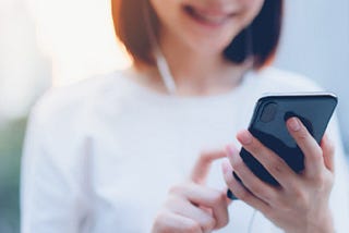 Young woman observing screen of mobile phone