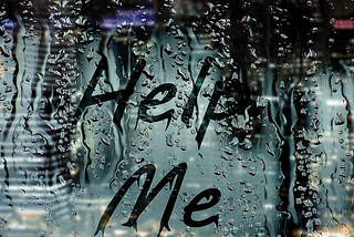 the words ‘help me’ written on a steamed up window