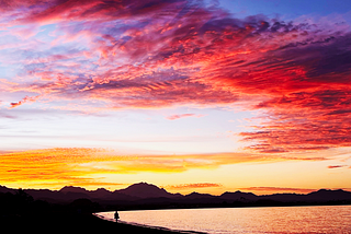 A woman enjoys a magenta and gold sunrise in Loreto, BCS, Mexico (photo credit: me)