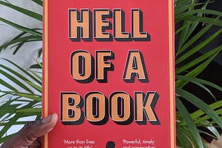 A picture of the “hell of a book” book cover with palm leaves in the background.