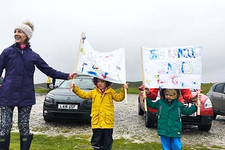 Liam’s family cheering him on from the side of the track, holding up banners in the cold, grey weather.