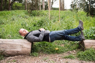 Tim Ferriss lying between two logs