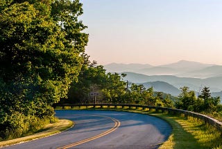 Road wrapping around tree with Appalachian Mountains in background