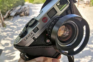 A Leica M6 camera with a halfcase leather case, in front of the beach in Yucatan, Mexico.