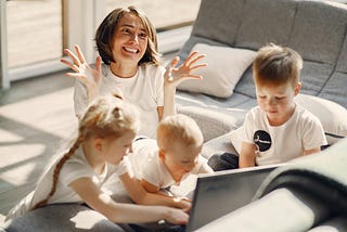 Mother throwing her hands in air, overwhelmed by the children with her.