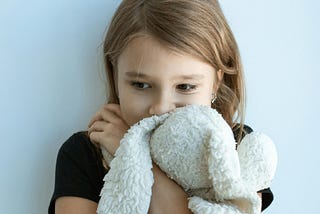 Sad child hugging a comfort toy
